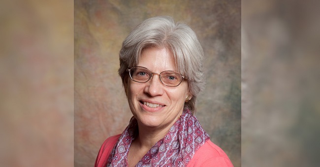 Studio picture of a woman looking at the camera, smiling.