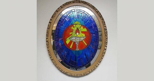 Oval mirror painted to give a stained glass effect, with a central image of a chalice.