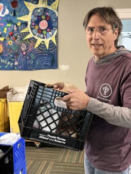 Man holding a milk-crate  box of supplies