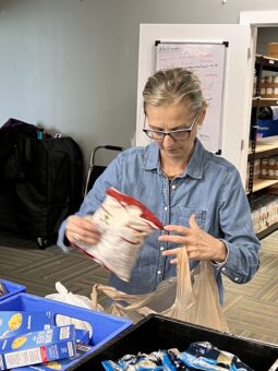 Woman loading a plastic grocery bag