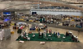 Scene looking down on the Exhibit Hall, showing booths and social areas.