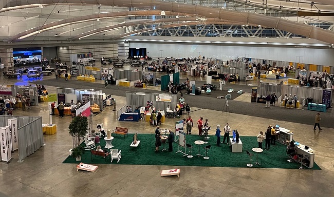 Scene looking down on the Exhibit Hall, showing booths and social areas.